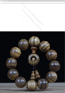 Macro detail of 108 Buddhist beads with tiger stripes and small gourd pendants