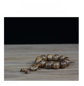 Detailed macro view of 108 agarwood beads showing natural tiger stripe wood textures