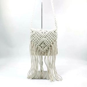 Detail of bohemian macramé shoulder bag featuring ivory cotton weave and long fringe trim