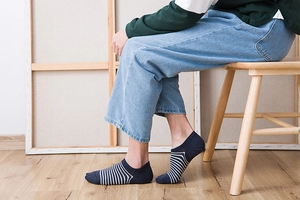Detailed view of dark blue and white striped low cut invisible socks on feet