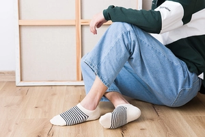 Close-up of white and black striped cotton blend no-show socks on model's feet