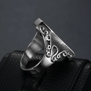 Vintage silver skull ring with ornate floral engraving shown on a black jewelry box