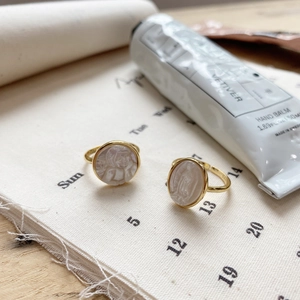 Macro detail of French vintage gold-plated rings with religious shell relief and portraits