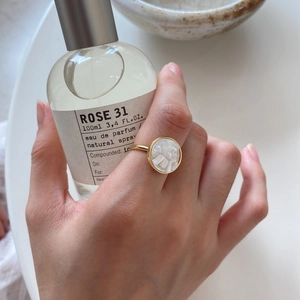 Detail of a vintage-style gold signet ring with a white portrait cameo relief