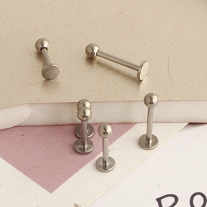 Macro detail of G23 titanium labret studs in various lengths with polished ball tops