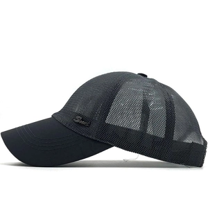 Détail du tissu en maille respirant et du logo Sport en métal sur la casquette grise