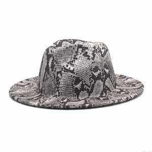 Detail of classic fedora hat featuring black and white snakeskin pattern and wide flat brim