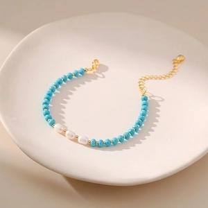 Macro view of blue faceted beads and natural freshwater pearls on a beaded bracelet