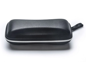 Detail of black litchi grain leather sunglass case with zipper and woven wrist strap