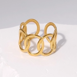 Detailed macro view of a gold-plated stainless steel hollow chain ring on a marble base