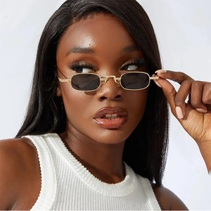 Close-up of retro small rectangular polarized sunglasses with gold metal frame on a model