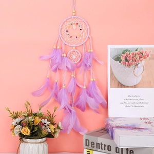 Close-up of purple dream catcher with delicate feathers and heart-shaped beads detail