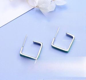 Detail view of minimalist square earrings with green enamel and polished silver finish