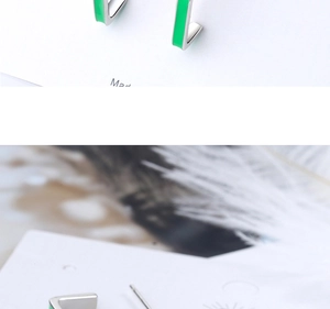 Macro shot of minimalist square studs with green glaze and silver metal base