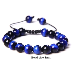 Macro detail of 8mm blue tiger eye bead bracelet with adjustable woven rope cord
