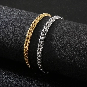 Close-up of gold and silver stainless steel Cuban chain bracelets with box clasps
