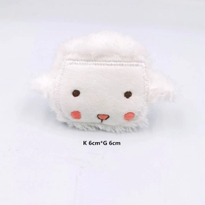 Detail shot of a plush white animal brooch with pink blush embroidery and 6x6cm size markings