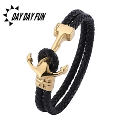 Detail of nautical braided black leather bracelet with a gold metal anchor clasp