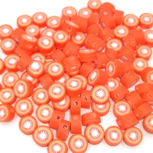 Macro detail of orange polymer clay fruit beads for DIY jewelry making and crafts