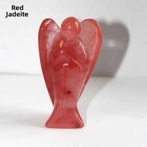 Close-up of red smelted quartz angel figurine with translucent finish on white surface