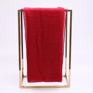 Lightweight red voile sunscreen scarf shown hanging on a modern gold metal frame