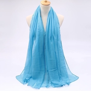 Detail of light blue sheer voile scarf draped on a model showing lightweight fabric texture