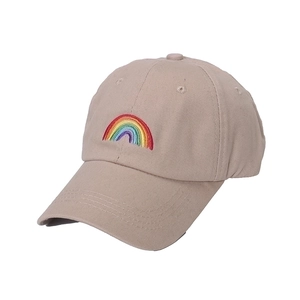 Side view of a beige cotton baseball cap featuring rainbow embroidery on a white background