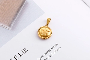 Macro view of gold stainless steel round pendant with embossed star and beaded edge