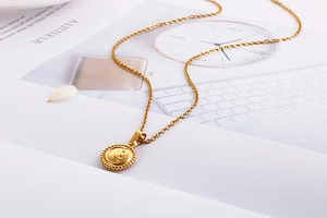Detailed view of a gold celestial pendant featuring a crescent moon and star on a link chain