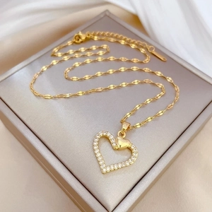 Luxury heart-shaped gold necklace with sparkling crystals on elegant silk background