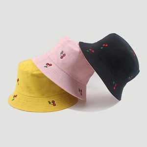 Close-up of cherry embroidery on cotton bucket hats in yellow, pink and black colors