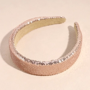 Close-up of sparkling rose gold sequin headband with soft beige inner lining