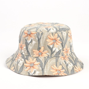 Close-up detail of floral cotton linen sun hat with orange daisy and leaf pattern textures