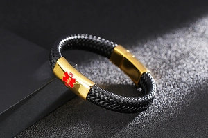 Detail of black woven leather medical alert bracelet with gold stainless steel charm