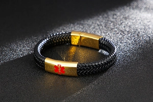 Macro shot of gold stainless steel medical alert clasp on black braided leather bracelet