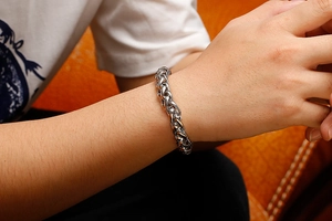 Gros plan d'un bracelet chaîne à mailles blé argenté porté au poignet avec détails polis
