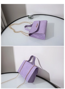 Dettaglio borsa lavanda motivo coccodrillo con tracolla a catena d'oro e logo