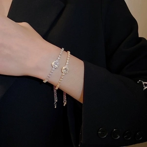Detail of adjustable bracelets with cubic zirconia accents on a wrist with black sleeve