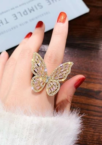 Close-up of elegant gold butterfly ring with sparkling crystals on a hand