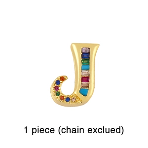 Close-up of golden letter J pendant with rainbow colorful zircon stones, chain excluded