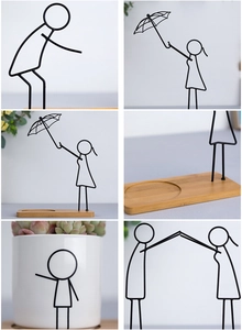 Detail of Nordic iron stick figure decor with wooden base and white ceramic succulent pot