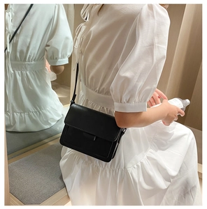 Classic black square flap crossbody bag with matte leather texture shown on model