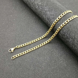 Classic gold-plated stainless steel Cuban link NK chain necklace on a dark textured background