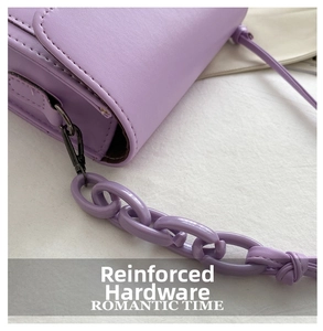 Detail of reinforced black metal hardware and purple link chain on small crossbody bag