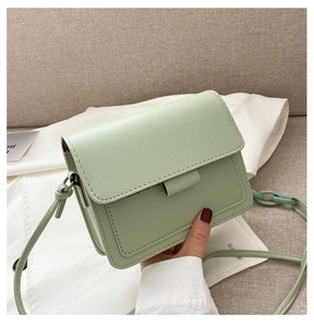Detail of mint green flap bag with leather texture and matching plastic chain