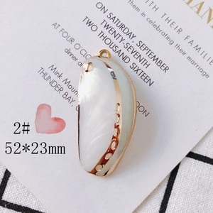 Macro shot of 52x23mm crescent shell pendant with golden edges for jewelry making