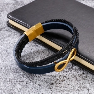 Detail of multi-layer navy leather bracelet with golden infinity symbol and magnetic clasp