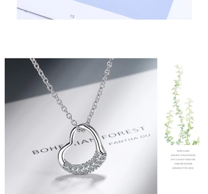 Detailed view of asymmetric heart pendant with pavé crystals on a silver chain