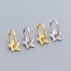 Macro shot of 925 silver star hoop earrings in gold and silver finish with zircon stones