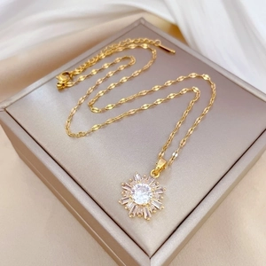 Luxurious gold snowflake necklace with sparkling crystals on white silk background